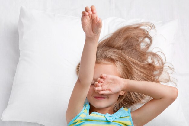 La foto del pequeño niño lindo adorable cubre los ojos