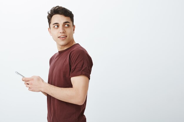 Foto de perfil de curioso modelo masculino europeo confiado en camiseta roja