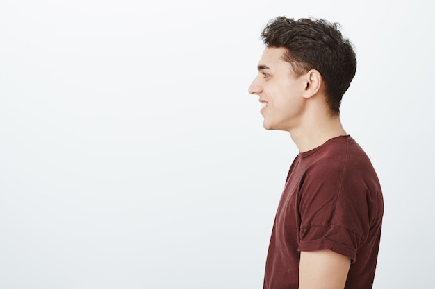 Foto gratuita foto de perfil de hombre europeo de aspecto amable positivo en camiseta roja