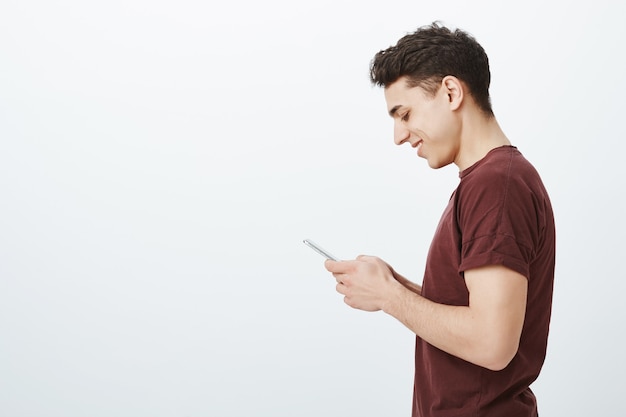 Foto de perfil de hombre guapo positivo en camiseta roja