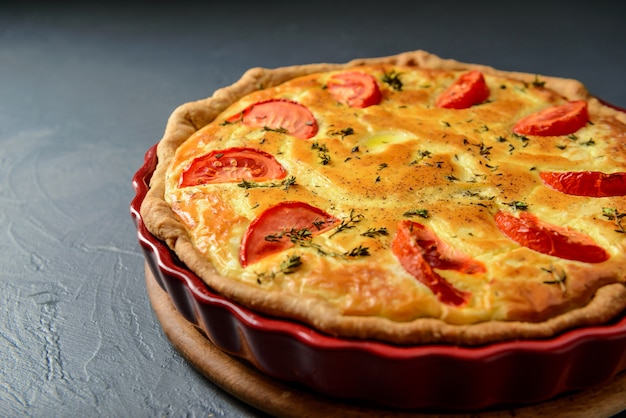 Foto de primer plano del clásico pastel de quiche lorraine con tomates