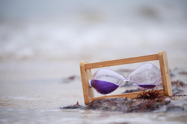 Foto de primer plano reloj de arena en la playa Foto de alta calidad