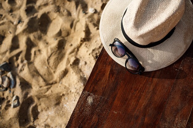 Foto de primer plano de sombrero y gafas en la playa