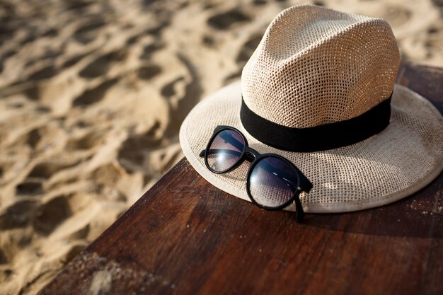 Foto de primer plano de sombrero y gafas en la playa