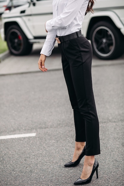Monopolio ira plato Foto recortada de dama de moda y elegante vestida con pantalón negro y blusa  blanca posando en el fondo de un coche al aire libre | Foto Gratis