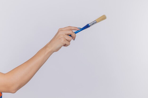 Foto recortada de la mano de una mujer sosteniendo un pincel