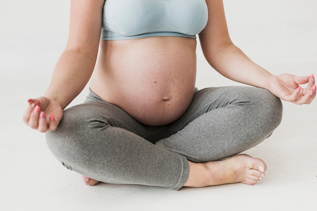 Foto recortada de mujer embarazada meditando