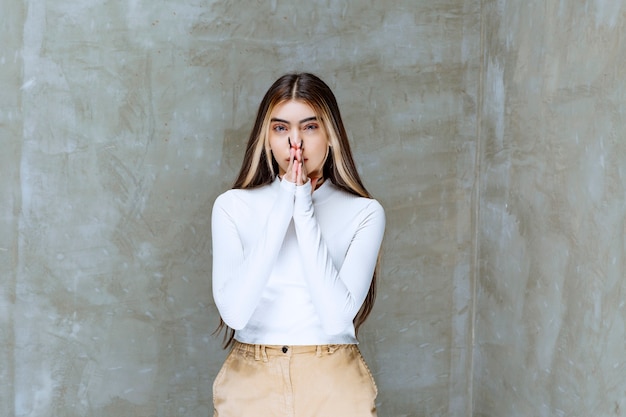 Foto de retrato de una hermosa niña modelo de pie y mirando a la cámara