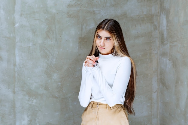 Foto de retrato de una hermosa niña modelo de pie y mirando a la cámara