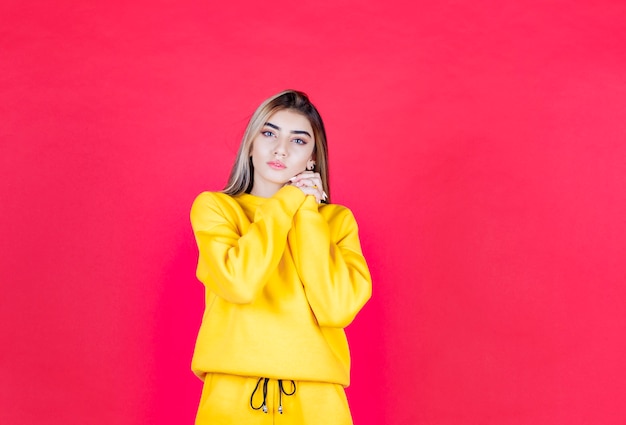 Foto de retrato de un modelo de niña seria de pie y mirando a la cámara