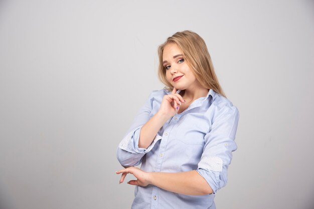 Foto de retrato de una mujer sonriente modelo de pie y mirando a la cámara