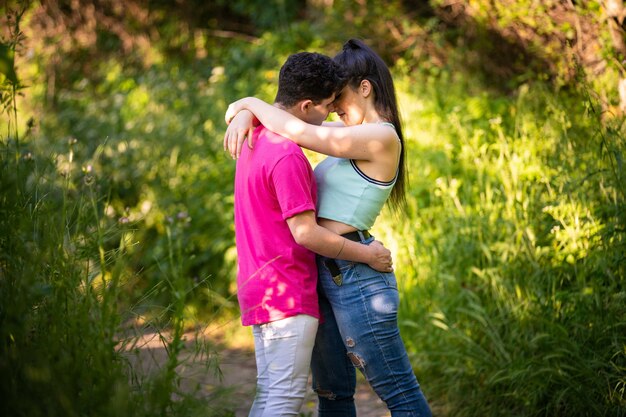 Foto romántica de una pareja abrazándose íntimamente en medio de un bosque