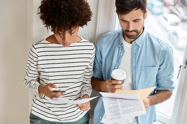 Foto gratuita foto de socios serios de raza mixta que discuten datos financieros