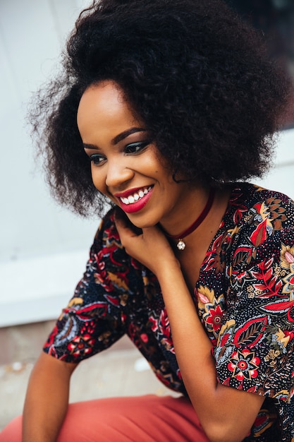 Foto de una sonriente mujer afroamericana atractiva con maquillaje colorido y dientes blancos