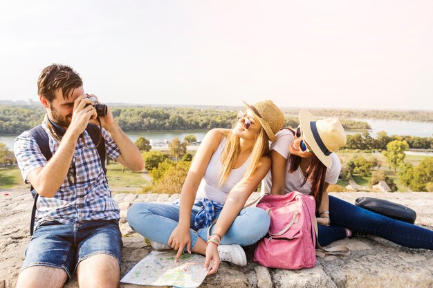 Foto de toma de hombre de dos amigas felices en cámara