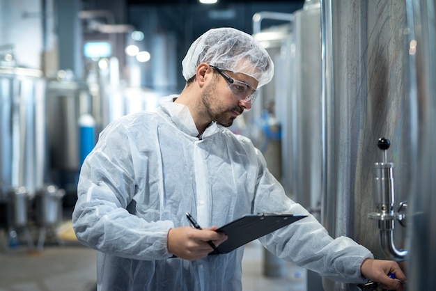 Foto de trabajador de tecnología concentrada de mediana edad que controla la producción en la industria farmacéutica o química