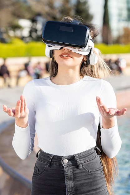 Foto gratuita foto vertical de una joven que usa gafas de realidad virtual en el parque foto de alta calidad