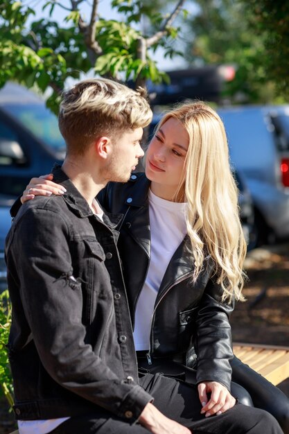 Foto vertical de una pareja joven con jeans negros y mirando el parque