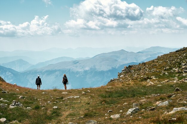 Foto de vista posterior de excursionistas de pie al borde de una colina en la Riviera francesa