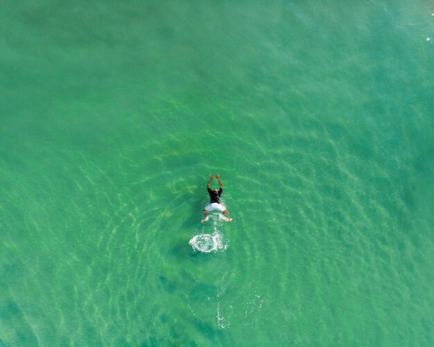 Foto de vista superior de una persona nadando en la playa de Varkala