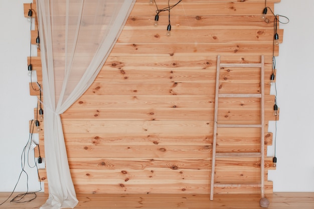 Una foto zona de madera, decorada con lúpulos, con bombillas y escalera.