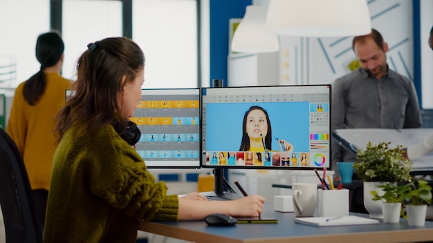 Fotógrafa edita fotos en la oficina de la agencia de medios creativos retocando cliente imagina con estil ...