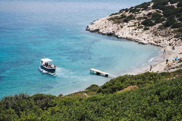 Fotografía aérea de un barco acercándose a la pequeña playa de Amorgos, Grecia