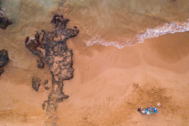 Fotografía aérea de una mujer tendida en la orilla de la playa
