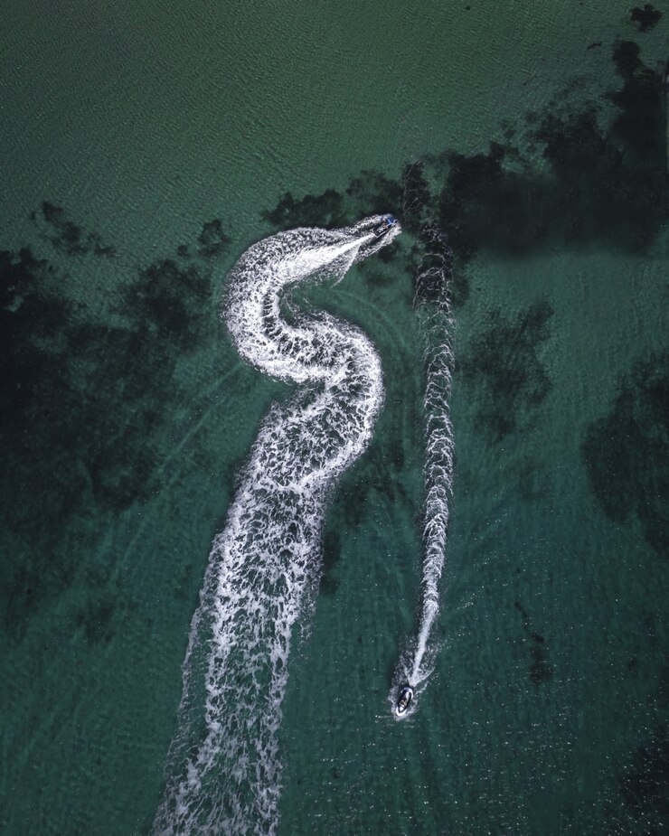 Foto gratuito fotografía aérea de yates que navegan por el mar dejando huellas de salpicaduras