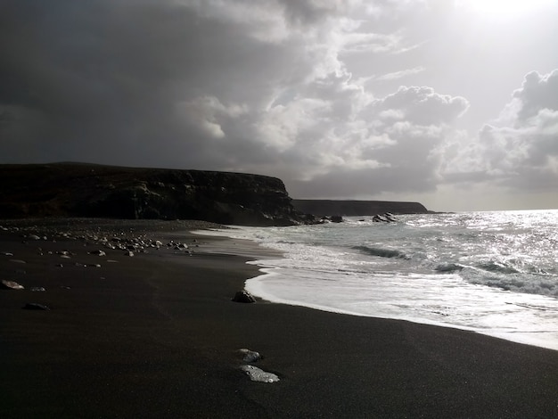 Foto gratuita fotografía en blanco y negro de olas tranquilas en la costa