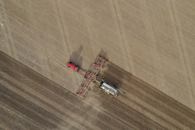 Fotografía cenital aérea de la máquina fertilizante en un campo agrícola durante el día