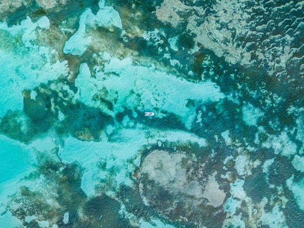 Fotografía cenital de un barco en un mar ondulado