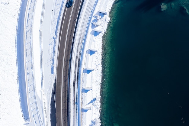 Foto gratuita fotografía cenital de una carretera asfaltada junto a un lago capturado durante el invierno