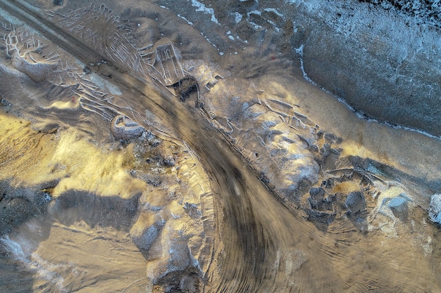 Fotografía cenital de una carretera rodeada de montañas y un campo agrícola en el campo