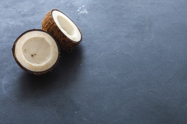 Fotografía cenital de cocos cortados sobre un fondo gris