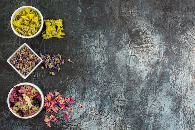 Foto gratuita fotografía cenital de flores secas en tazones blancos en el lado izquierdo de gris