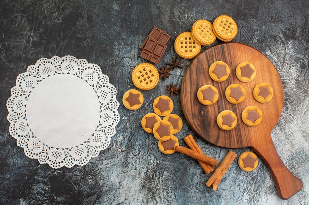 Fotografía cenital de galletas en bandeja de madera con un trozo de encaje blanco sobre gris