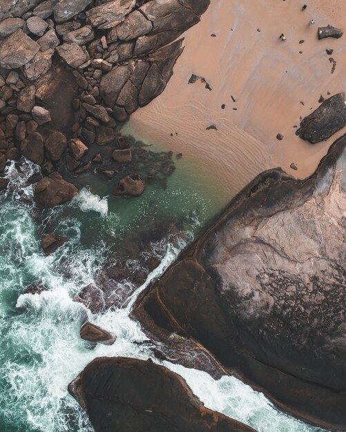 Fotografía cenital de un hermoso canal de agua con rocas y gente alrededor