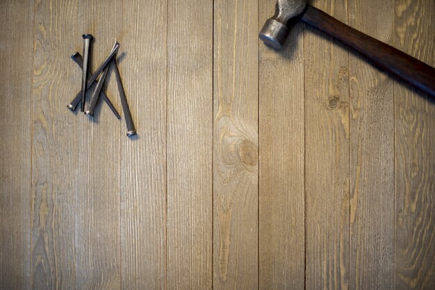 Fotografía cenital de martillo y clavos sobre una superficie de madera