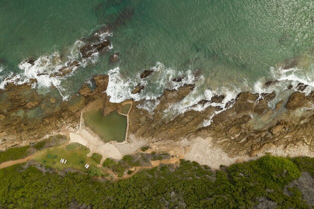 Fotografía cenital de una orilla del mar con agua verde pura durante el día