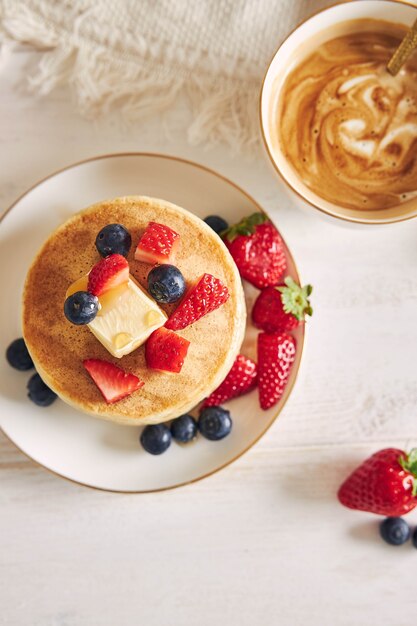 Fotografía cenital de panqueques veganos con frutas en el desayuno