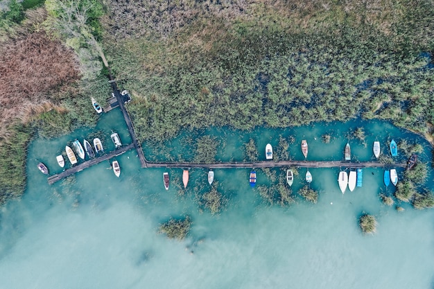 Fotografía cenital de un pequeño muelle en la costa con barcos de pesca estacionados
