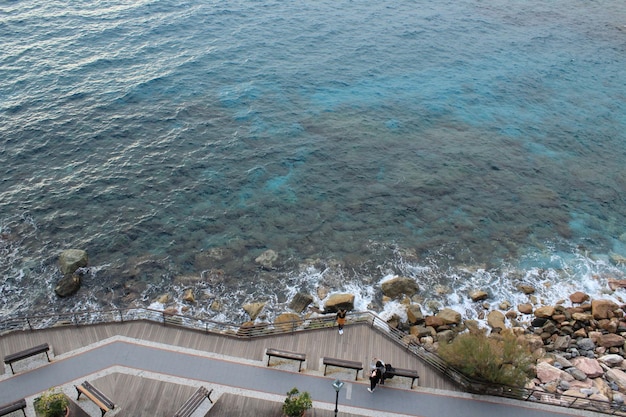 Foto gratuita fotografía cenital de personas tomando una foto cerca de la costa rocosa y un mar