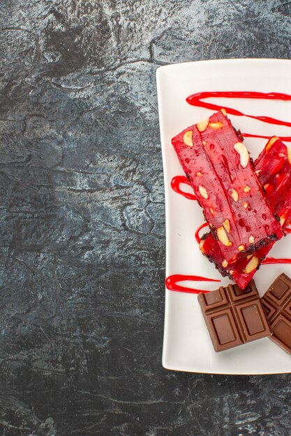 Fotografía cenital de un plato de barras de chocolate en el lado derecho de gris