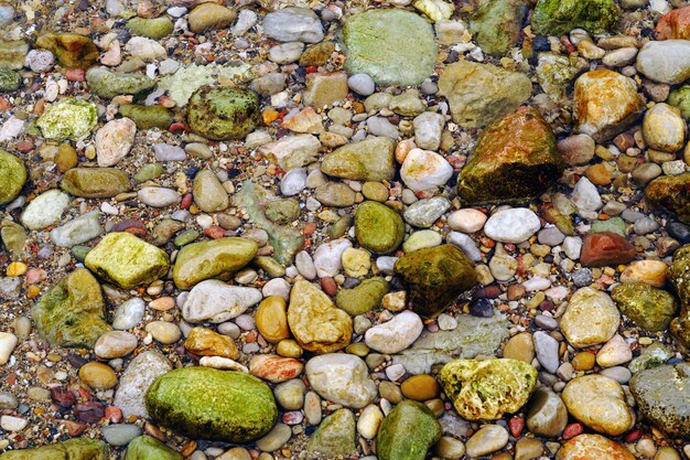 Fotografía cenital de la playa llena de piedras de colores