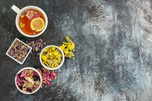 Foto gratuita fotografía cenital de té de hierbas cerca de tazones de flores secas sobre suelo gris