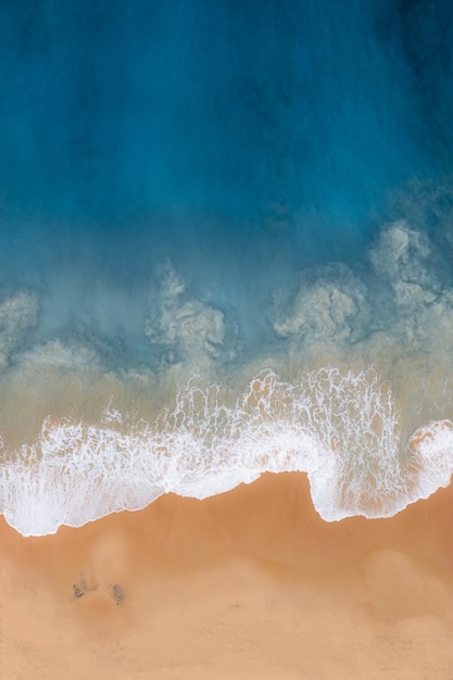 Fotografía cenital vertical de un mar ondulado contra la orilla del mar