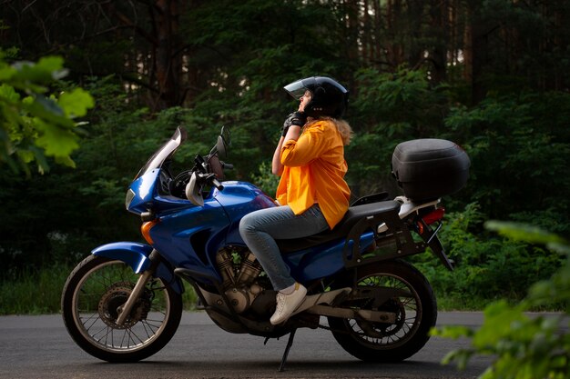 Fotografía completa de una anciana con motocicleta