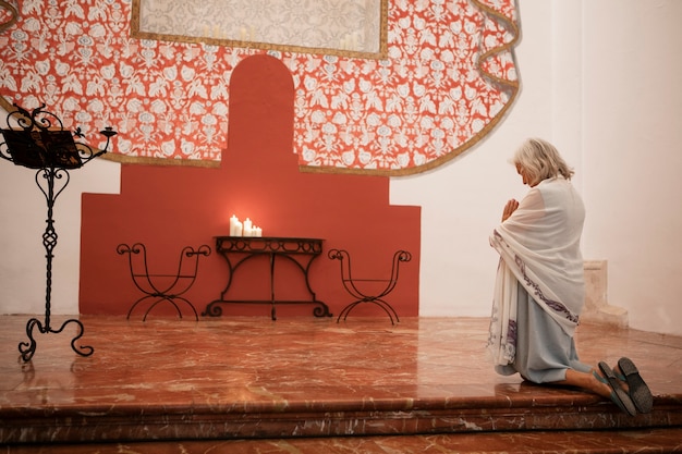 Foto gratuita fotografía completa de una anciana orando en la iglesia.