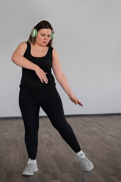 Fotografía completa de una mujer bailando en el estudio.